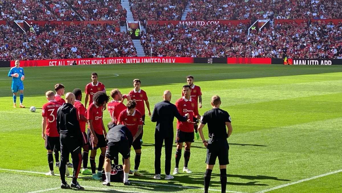 Manchester United players gathered on the pitch during a break at Old Trafford
